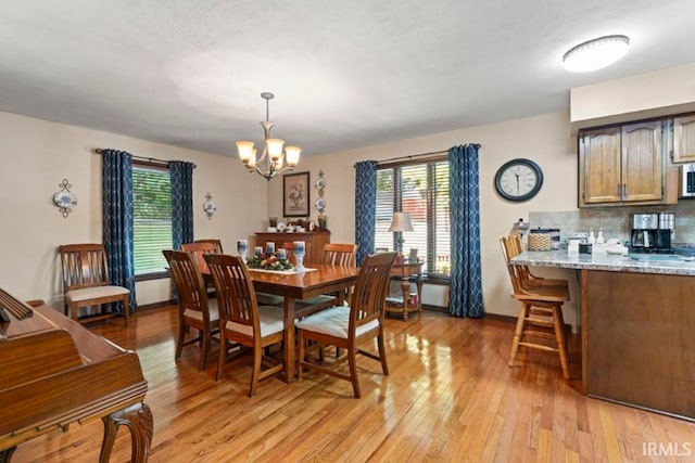 dining area featuring a notable chandelier and light wood-type flooring