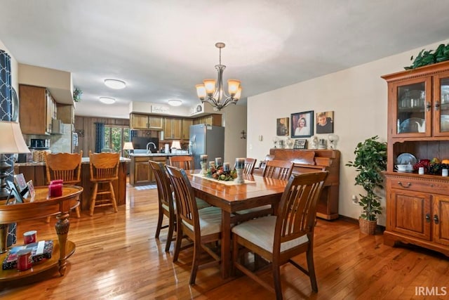 dining room featuring light hardwood / wood-style floors and a notable chandelier