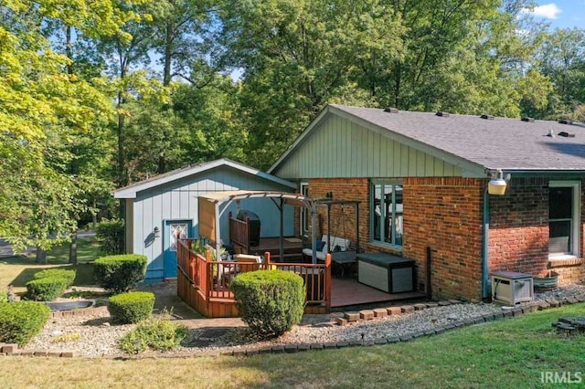 back of property with a wooden deck and a lawn