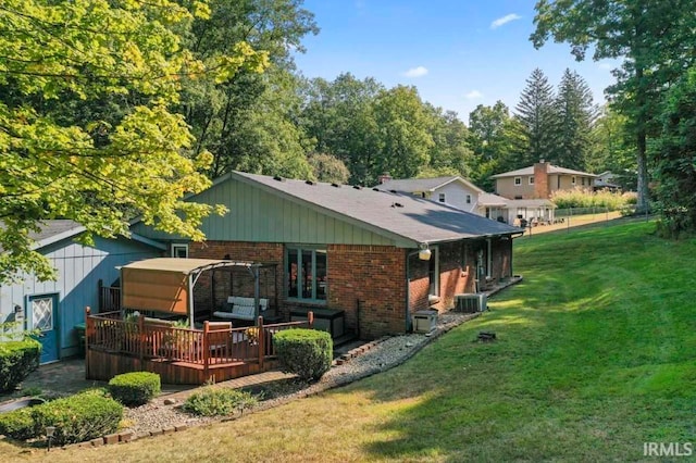 back of house featuring a lawn, a wooden deck, and cooling unit