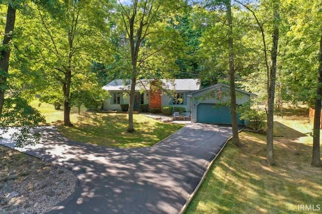 ranch-style house featuring a garage and a front lawn