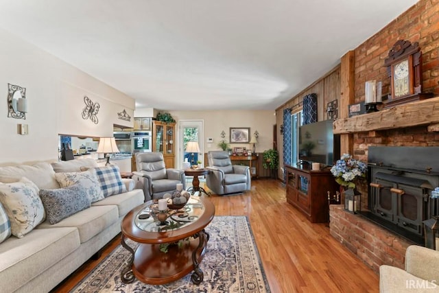 living room featuring a brick fireplace and light hardwood / wood-style floors