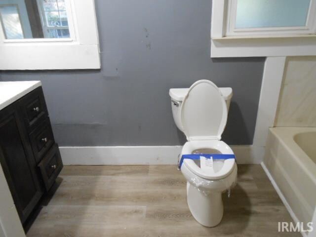 bathroom with vanity, toilet, hardwood / wood-style floors, and a tub