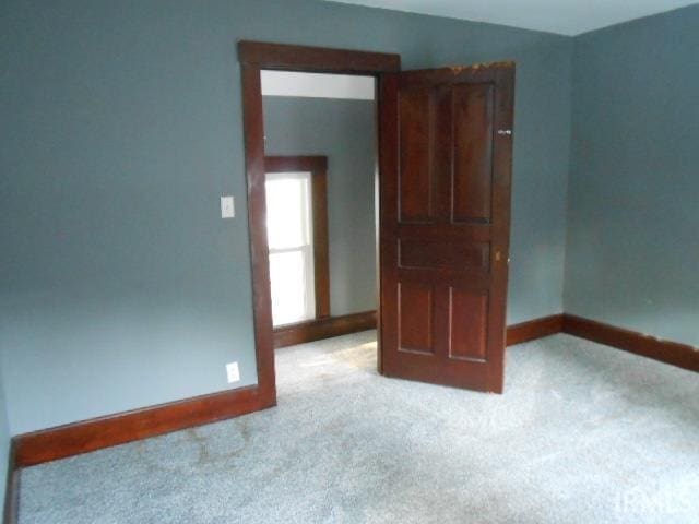 unfurnished room featuring light carpet