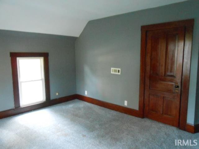 bonus room featuring vaulted ceiling and light colored carpet