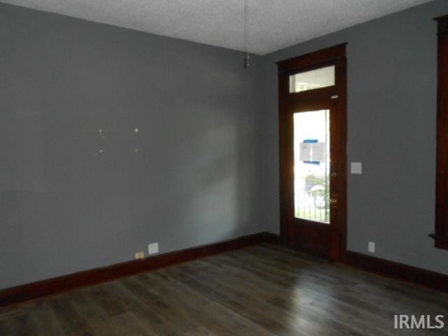 unfurnished room featuring hardwood / wood-style flooring and a textured ceiling