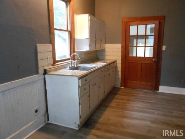 kitchen with light hardwood / wood-style flooring, sink, and white cabinets