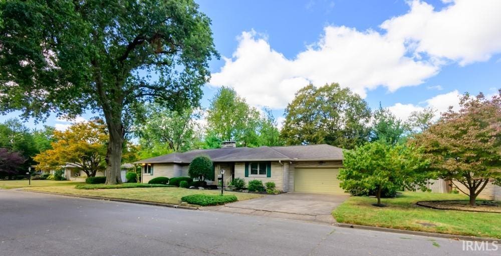 ranch-style house with a garage and a front lawn