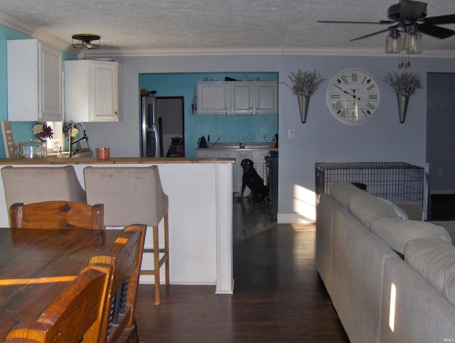 kitchen featuring white cabinetry, stainless steel refrigerator, ceiling fan, and dark hardwood / wood-style floors