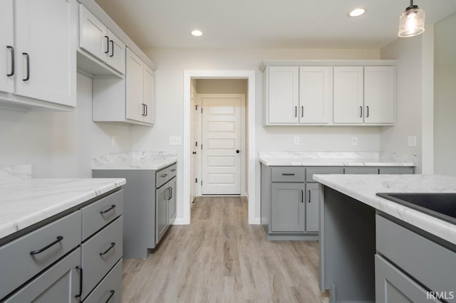 kitchen featuring light wood-style flooring, light stone counters, gray cabinets, pendant lighting, and recessed lighting