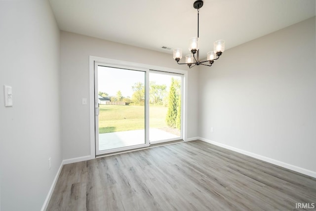 interior space featuring a chandelier, light wood-type flooring, visible vents, and baseboards