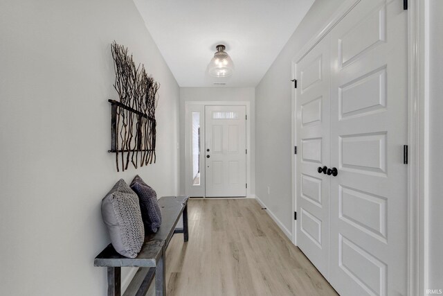 laundry area featuring laundry area, light wood-style flooring, baseboards, and electric dryer hookup