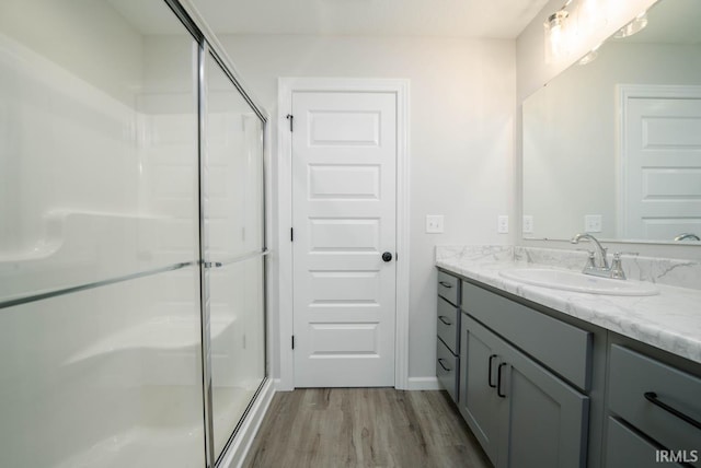 bathroom featuring a stall shower, vanity, and wood finished floors