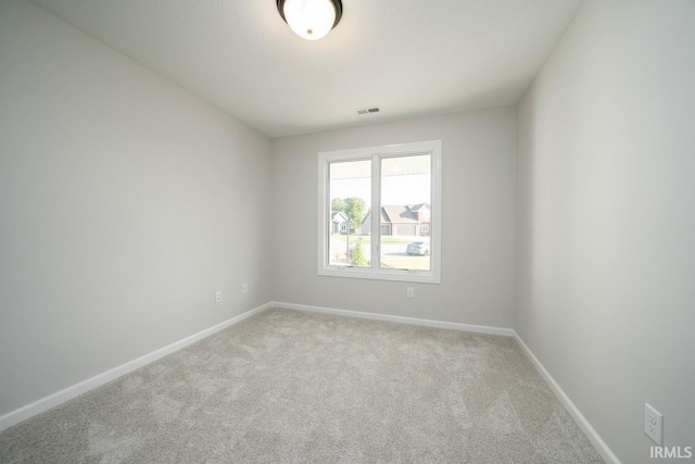 carpeted spare room featuring visible vents and baseboards