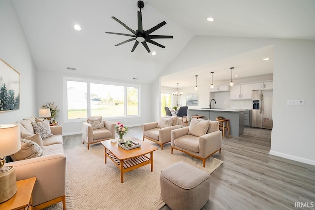 living room featuring light wood-type flooring, baseboards, visible vents, and recessed lighting