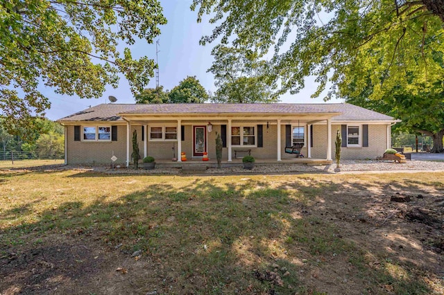 ranch-style house featuring covered porch and a front yard