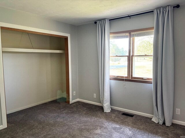 unfurnished bedroom with dark carpet