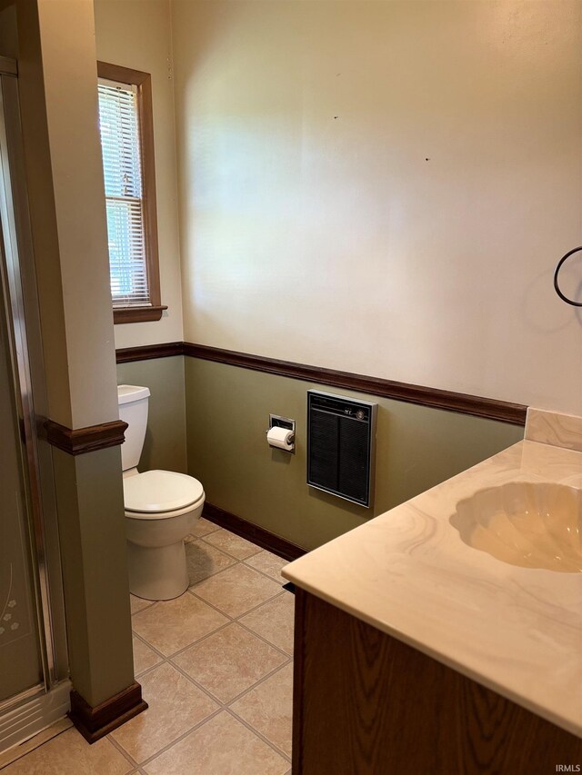 bathroom featuring tile patterned floors, toilet, heating unit, and vanity