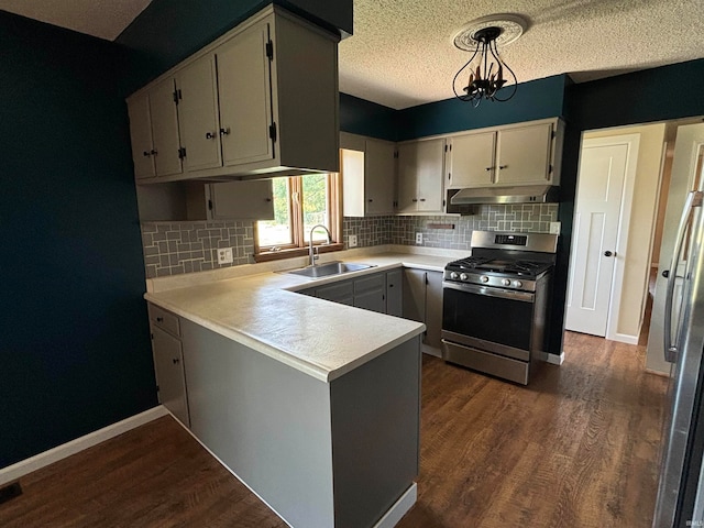 kitchen featuring sink, decorative light fixtures, appliances with stainless steel finishes, and dark hardwood / wood-style flooring