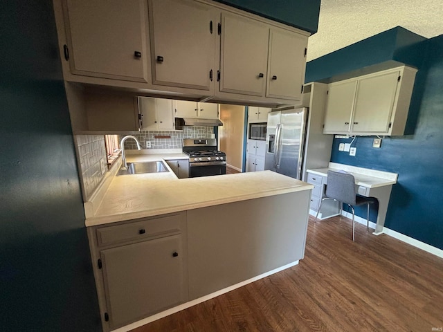 kitchen with hardwood / wood-style flooring, stainless steel appliances, sink, kitchen peninsula, and cream cabinetry