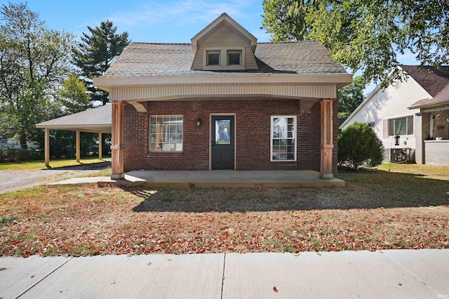 view of front facade with covered porch, a carport, and central air condition unit