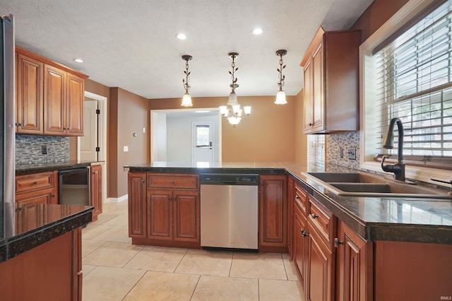 kitchen with backsplash, dishwasher, an inviting chandelier, decorative light fixtures, and sink