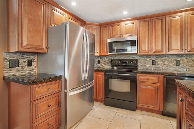 kitchen with dark stone countertops, black appliances, backsplash, and light tile patterned floors