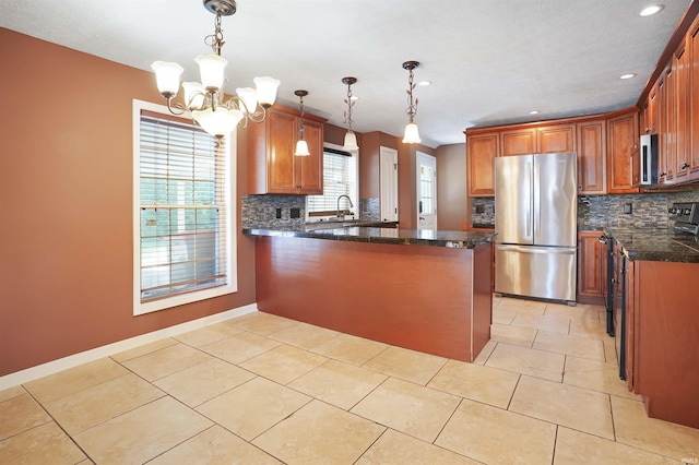 kitchen with pendant lighting, stainless steel appliances, a chandelier, and tasteful backsplash