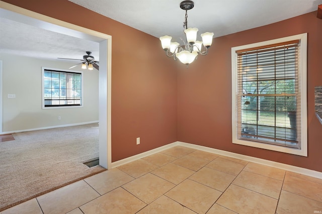 carpeted empty room with a textured ceiling and ceiling fan with notable chandelier