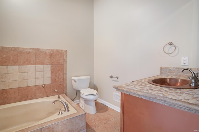 bathroom featuring tiled tub, vanity, toilet, and tile patterned floors