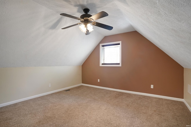 bonus room with lofted ceiling, carpet flooring, ceiling fan, and a textured ceiling