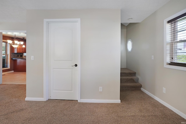 interior space featuring carpet flooring and an inviting chandelier