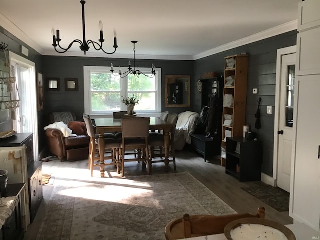 dining space with dark hardwood / wood-style floors, a chandelier, and crown molding