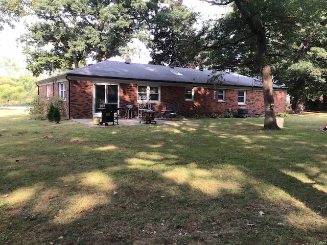 back of property featuring a lawn and a patio area