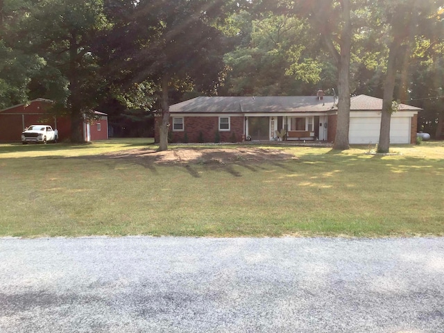 single story home featuring a storage shed, a garage, and a front lawn