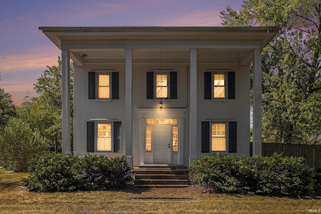 view of front of home featuring fence and brick siding