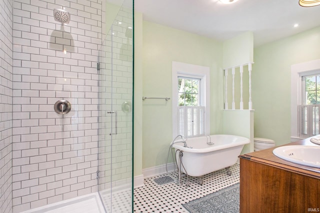 full bathroom with vanity, a healthy amount of sunlight, independent shower and bath, and toilet