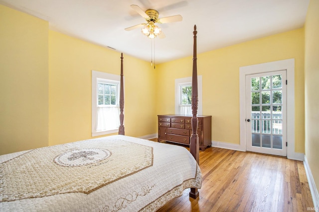 bedroom with light wood-type flooring, multiple windows, access to exterior, and ceiling fan