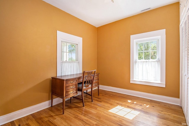 office featuring hardwood / wood-style flooring and a healthy amount of sunlight