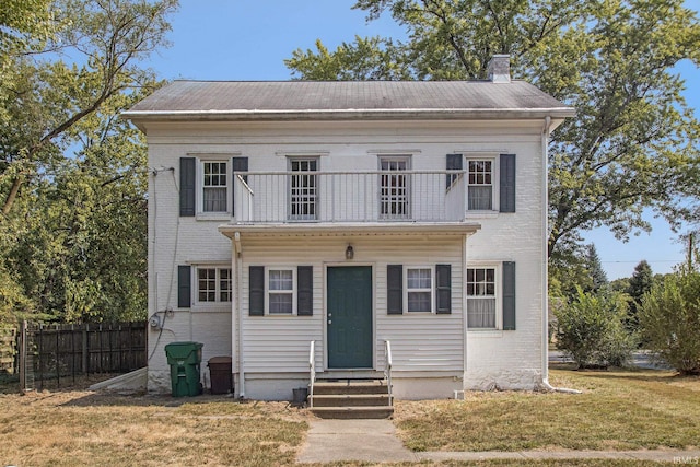 view of front of home with a balcony and a front lawn