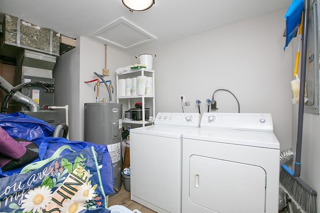 laundry room with washer and dryer, light hardwood / wood-style floors, and electric water heater