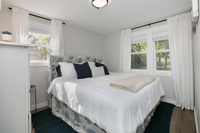 bedroom with dark hardwood / wood-style flooring