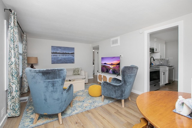 living room featuring a textured ceiling and light hardwood / wood-style flooring