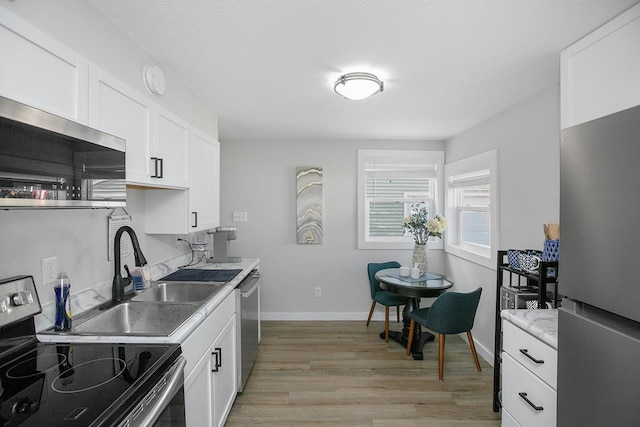 kitchen featuring light hardwood / wood-style flooring, sink, stainless steel appliances, and white cabinets