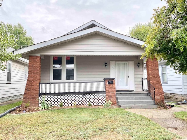 view of front of home featuring covered porch and a front lawn