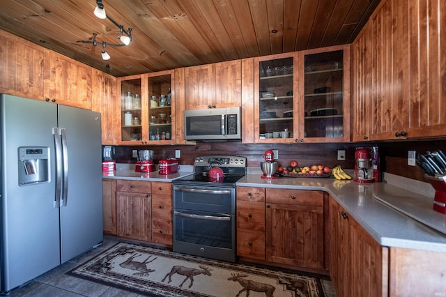 kitchen featuring wood ceiling, dark tile patterned floors, and stainless steel appliances