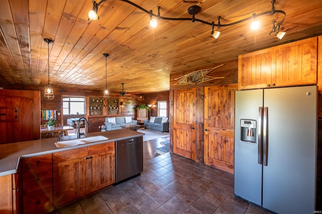 kitchen with wooden walls, appliances with stainless steel finishes, wood ceiling, sink, and pendant lighting