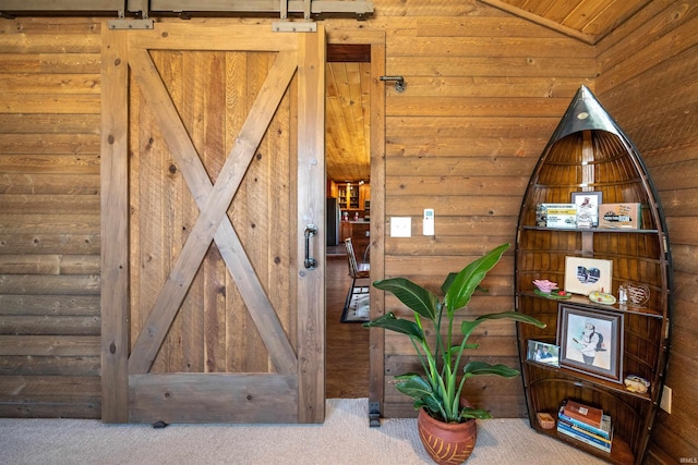 interior space with a barn door and wood walls