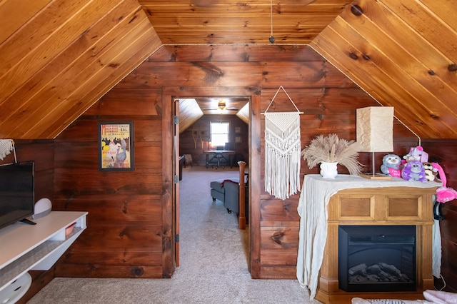 unfurnished bedroom featuring lofted ceiling, wood walls, and carpet flooring