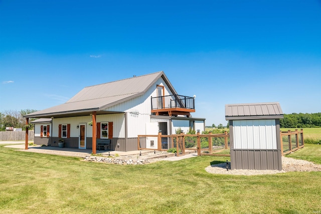 back of house with a balcony, a yard, and a patio area